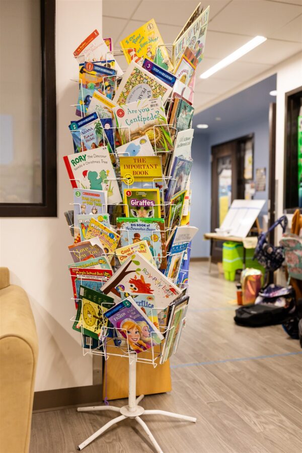 Innovations Academy (IA) revolving book display stand filled with many colorful books.